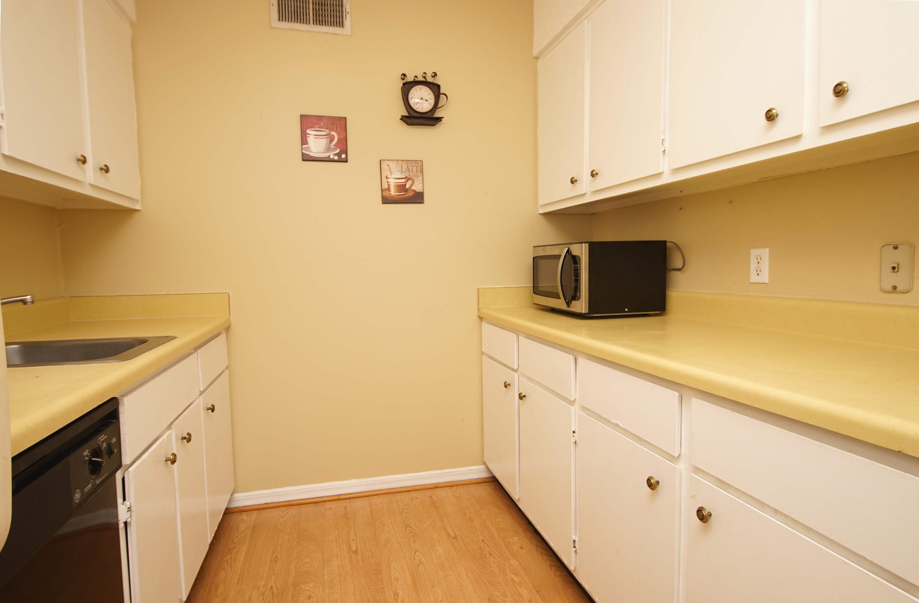 210 Pelham Road, Unit 219C Fort Walton Beach, FL 32547 - Photo 10 of 23 a kitchen with granite countertop white cabinets and stainless steel appliances