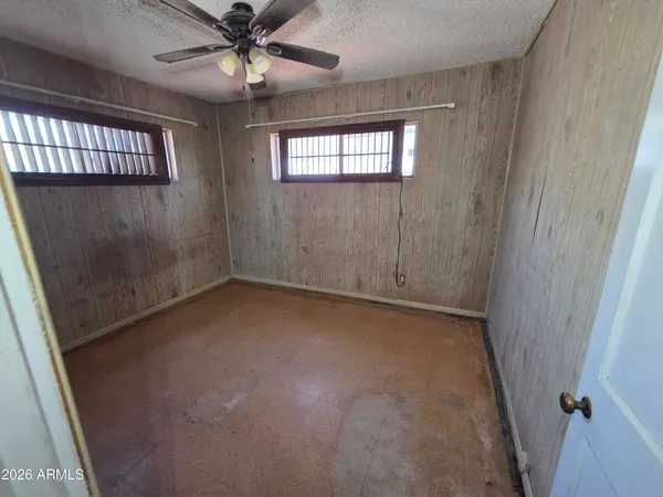 an empty room with windows and fan