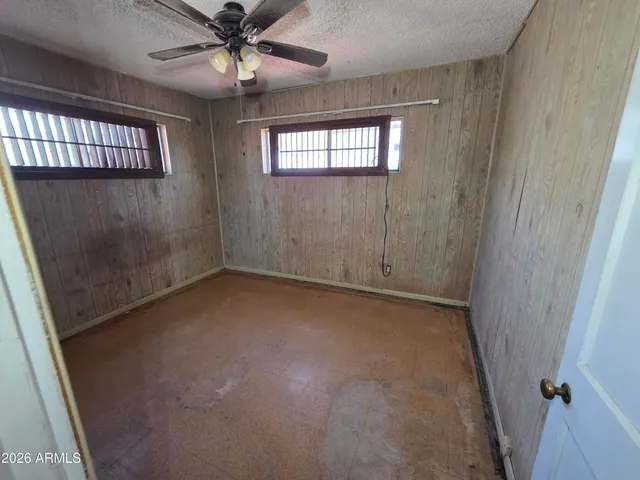 an empty room with windows and fan