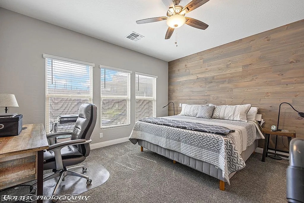 1304 Cottage Ridge Mesquite, NV 89034 - Photo 16 of 52 A comfortable bedroom with a modern rustic accent wall and ample natural illumination through three large windows.