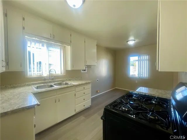 a kitchen with a stove a sink and a window