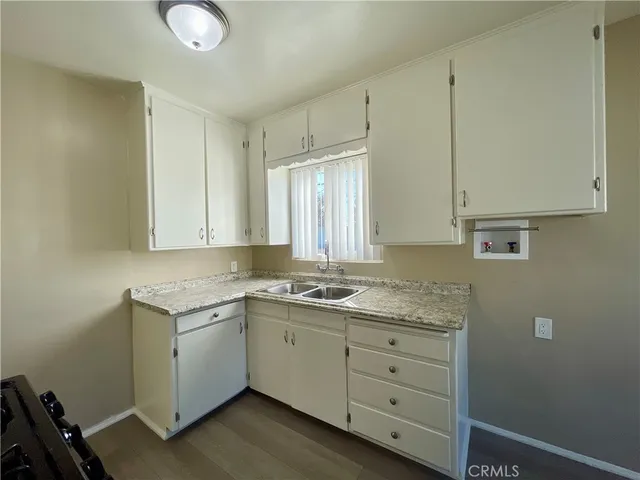 a kitchen with cabinets appliances a sink and a window