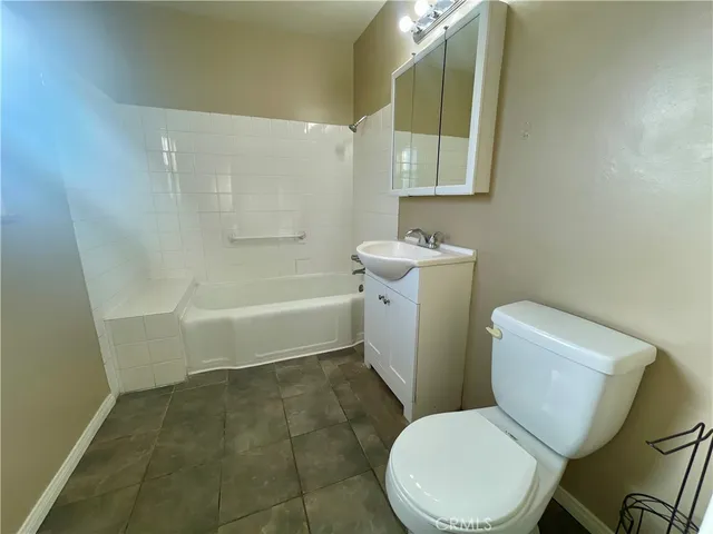 a white toilet sitting next to a bathroom sink and a mirror