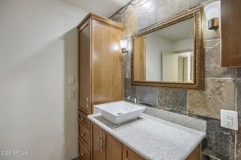 a bathroom with a granite countertop sink and a mirror