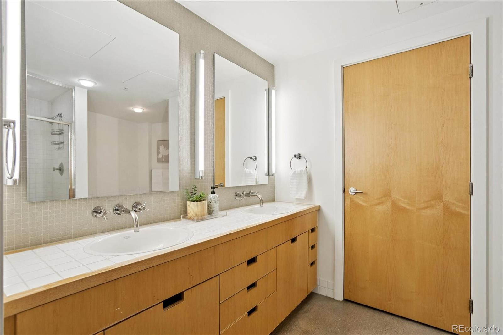 1610 Little Raven Street, Unit 511 Denver, CO 80202 - Photo 21 of 34 a bathroom with a double vanity sink and a mirror