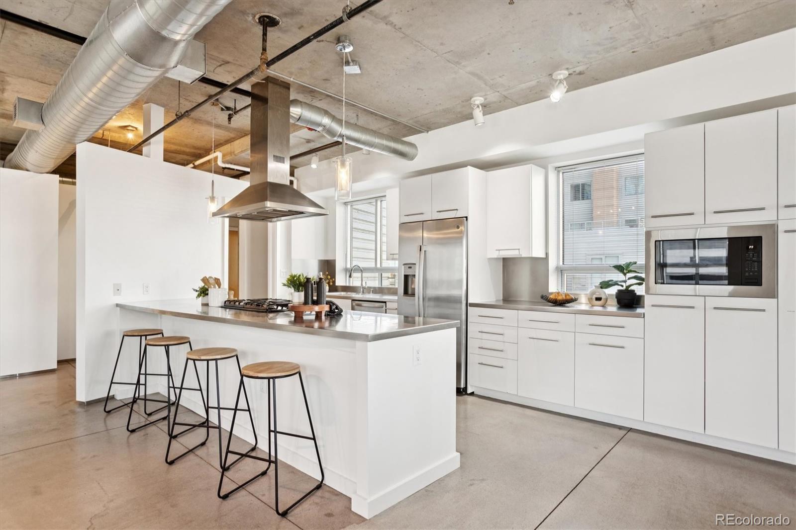 1610 Little Raven Street, Unit 511 Denver, CO 80202 - Photo 4 of 34 a kitchen with cabinets and chairs