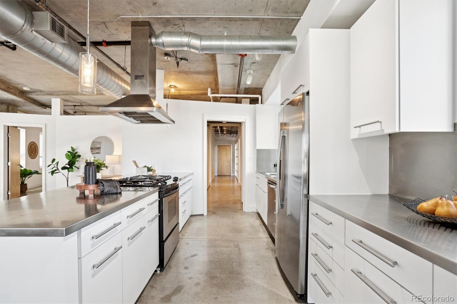 1610 Little Raven Street, Unit 511 Denver, CO 80202 - Photo 5 of 34 a kitchen with stainless steel appliances granite countertop a sink stove and refrigerator