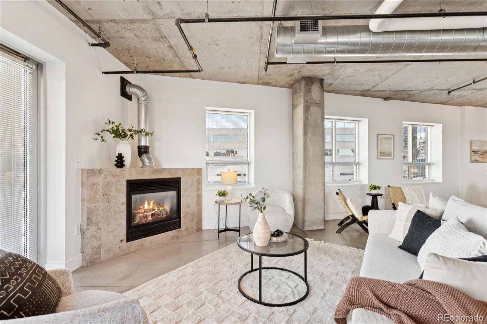 1610 Little Raven Street, Unit 511 Denver, CO 80202 - Photo 10 of 34 a living room with furniture a fireplace and a dining table with wooden floor