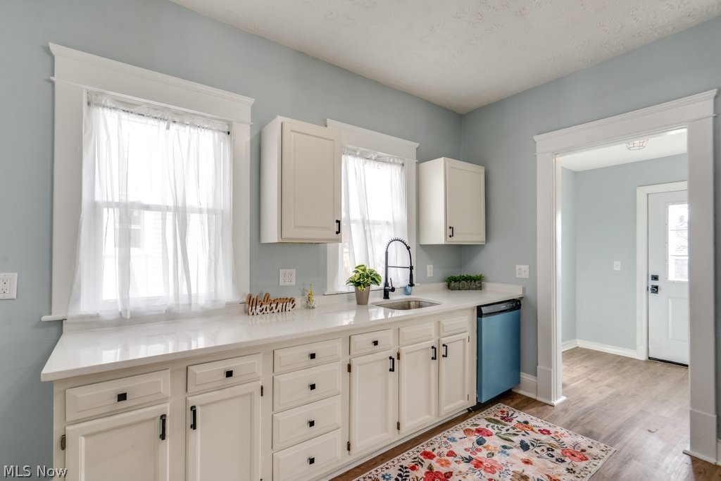 12 South 4th Street Rittman, OH 44270 - Photo 15 of 48 Kitchen featuring dishwasher, white cabinets, light stone countertops, light wood-style flooring, and a textured ceiling