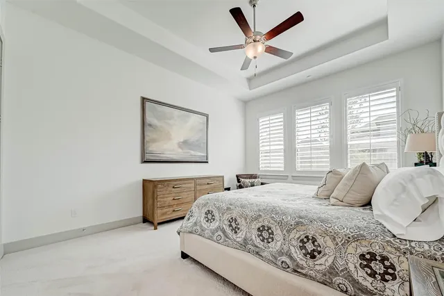 a bedroom with a large bed and ceiling fan