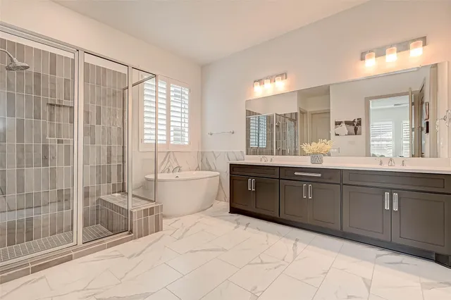 a spacious bathroom with a granite countertop sink a toilet a mirror and shower