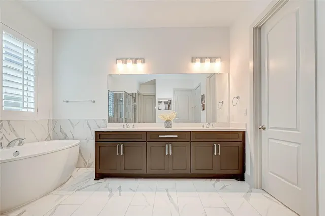a spacious bathroom with a tub sink and mirror