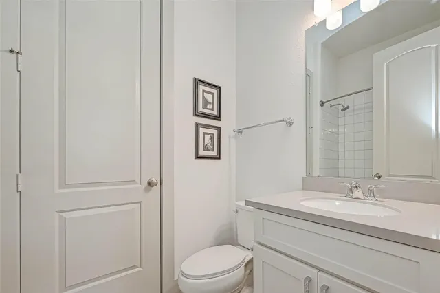 a bathroom with a granite countertop toilet a sink and a mirror