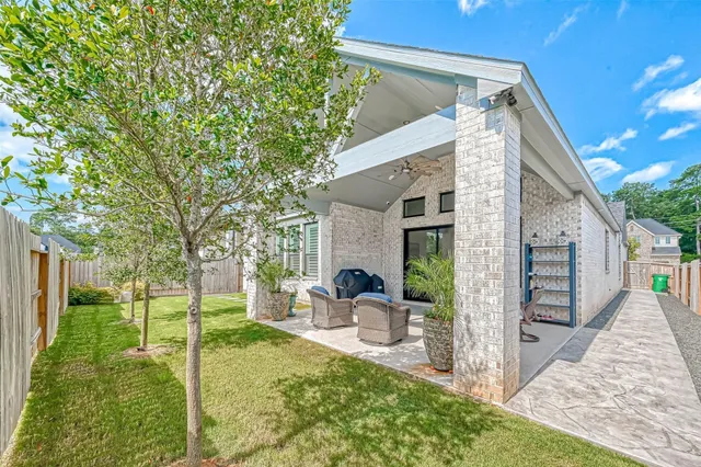 a view of a house with backyard and a tree