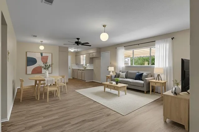 a living room with furniture a wooden floor and a large window