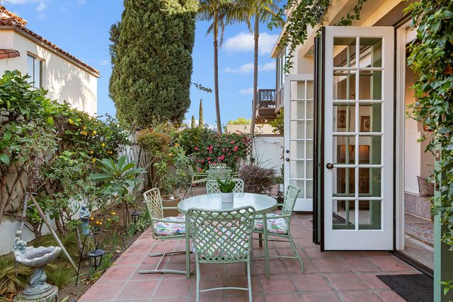 a view of a patio with a table and chairs and potted plants