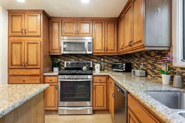 a kitchen with granite countertop a sink stove and cabinets