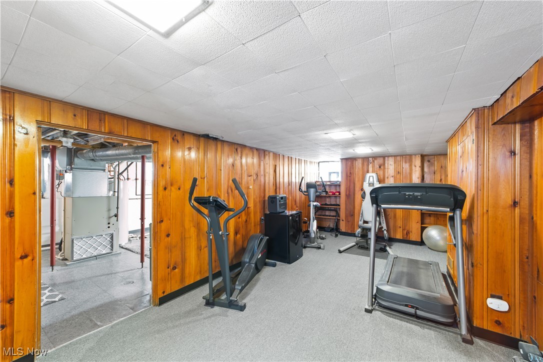 13629 Cedar Road Cleveland, OH 44118 - Photo 9 of 12 Exercise area featuring heating unit, light carpet, and wooden walls
