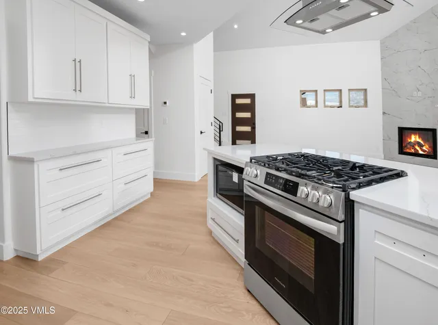 a kitchen with white cabinets and appliances