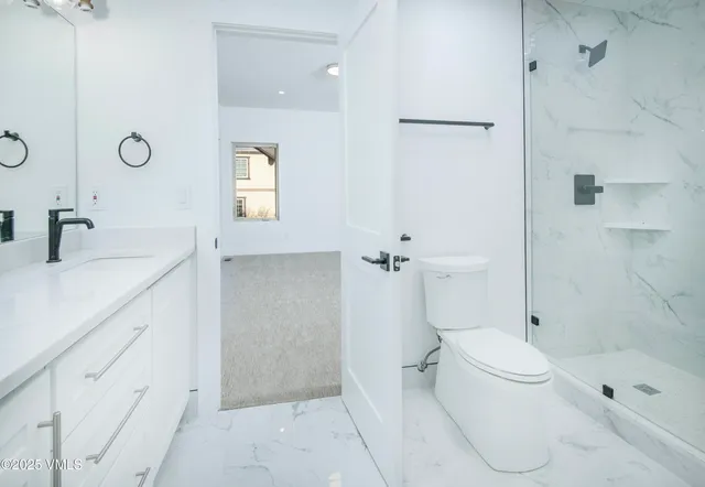 a bathroom with a sink a toilet and shower