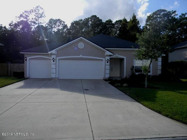 a front view of a house with yard and green space