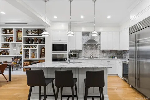 a kitchen with stainless steel appliances granite countertop a stove a refrigerator a oven a sink with a dining table and chairs