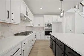 a kitchen with kitchen island white cabinets and white appliances