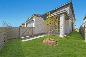 a backyard of a house with lots of plants and wooden fence