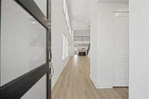 a view of a hallway with wooden floor and a living room