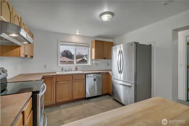 a kitchen with stainless steel appliances granite countertop a refrigerator sink and stove