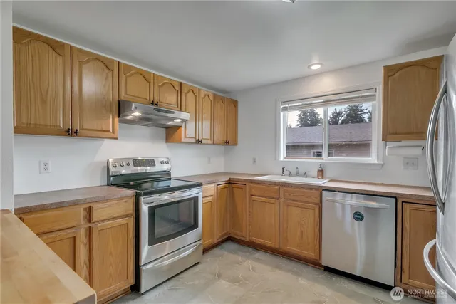 a kitchen with stainless steel appliances granite countertop a sink stove and cabinets