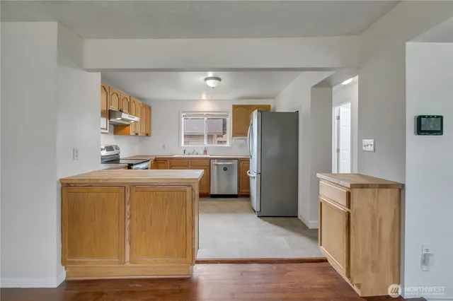 a kitchen with a refrigerator a sink and a stove top oven
