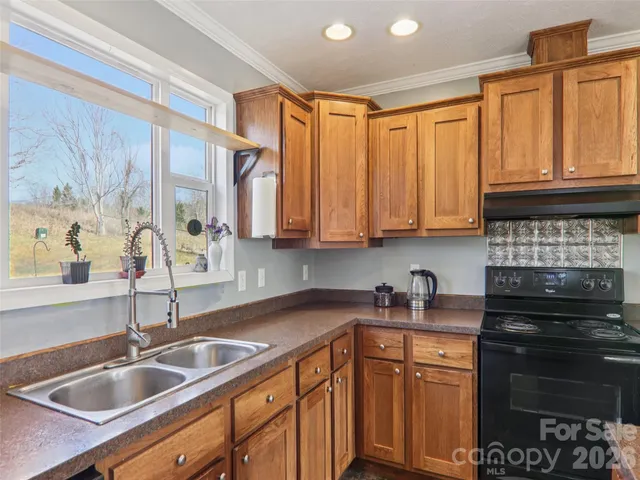 a kitchen with stainless steel appliances granite countertop a sink stove and cabinets