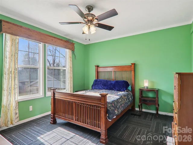 a bedroom with a bed and windows