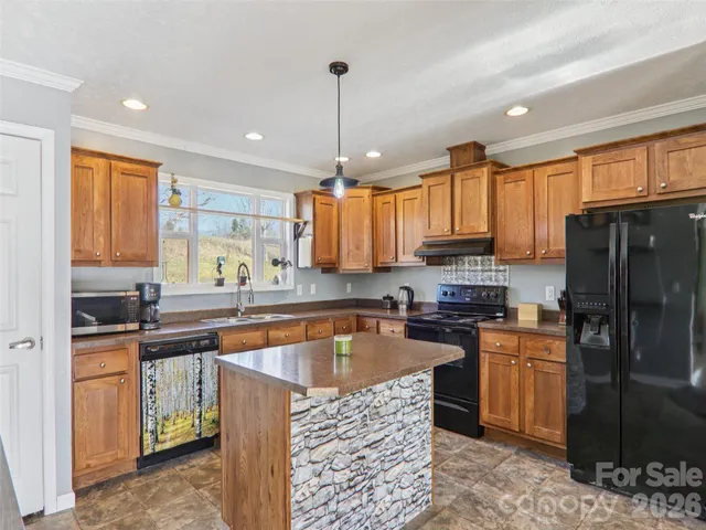 a kitchen with kitchen island granite countertop a sink stove and refrigerator