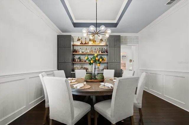 a view of a dining room with furniture a chandelier and wooden floor