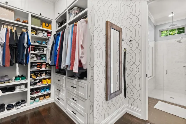 a view of walk in closet with clothes and shoes