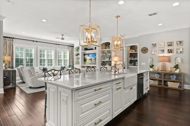 a kitchen with stainless steel appliances granite countertop a stove and white cabinets with wooden floor