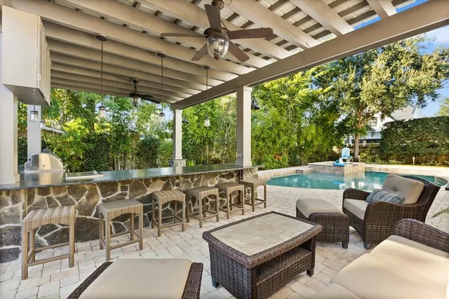 a view of a patio with table and chairs potted plants and large tree