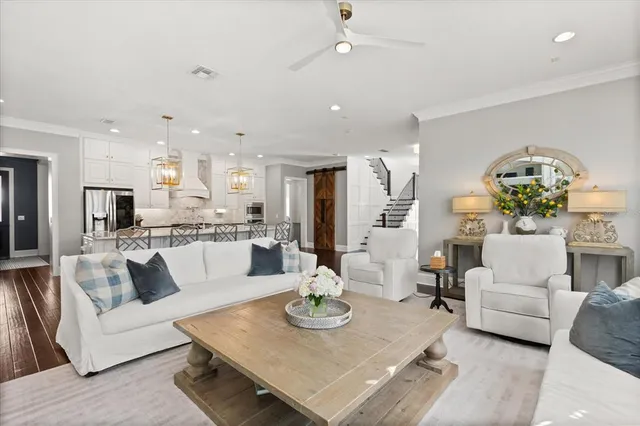 a living room with stainless steel appliances furniture and a dining table