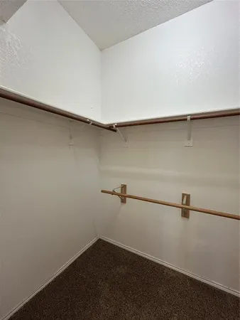 an empty room with a chandelier fan and windows