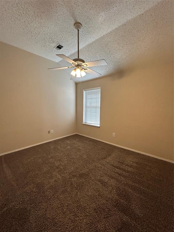3805 Pine Valley Drive Plano, TX 75025 - Photo 12 of 16 an empty room with a chandelier fan and windows