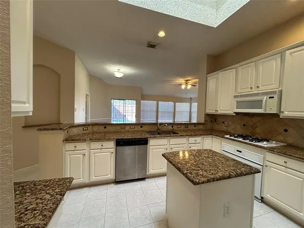 a kitchen with a stove sink and cabinets