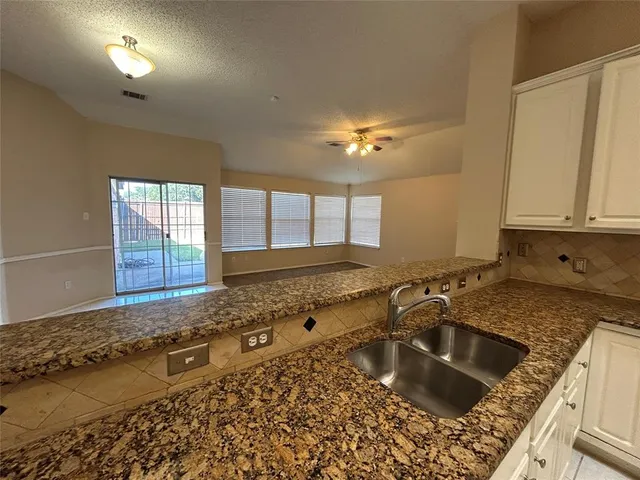 a kitchen with a sink a stove and cabinets