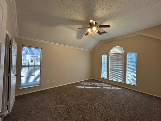 an empty room with windows and fan