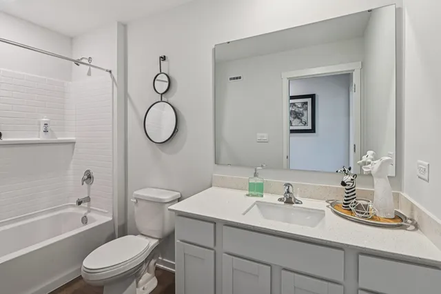 a bathroom with a granite countertop toilet sink and a mirror