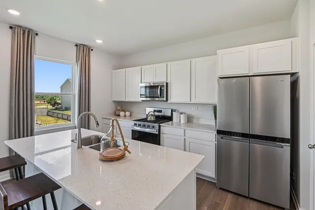a kitchen with refrigerator cabinets and wooden floor