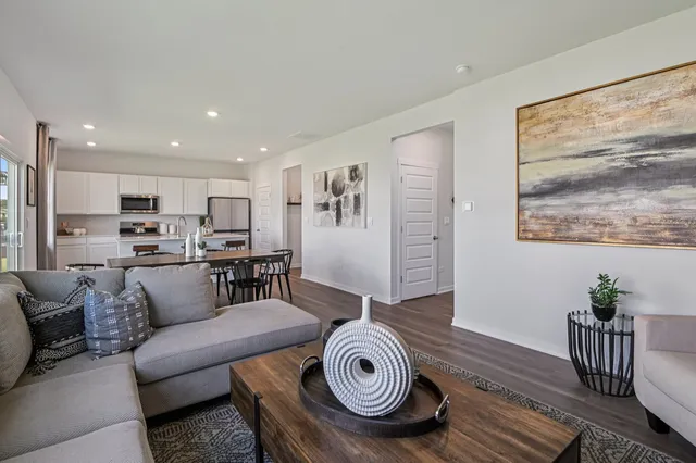a living room with furniture and a view of kitchen