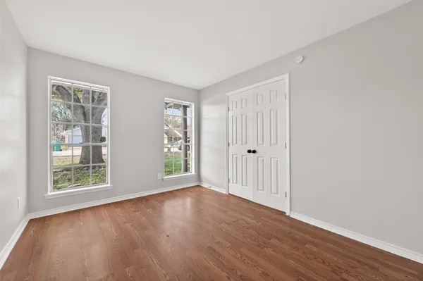 a view of empty room with wooden floor