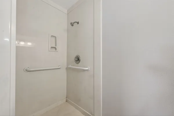 an empty room with a window and a fan